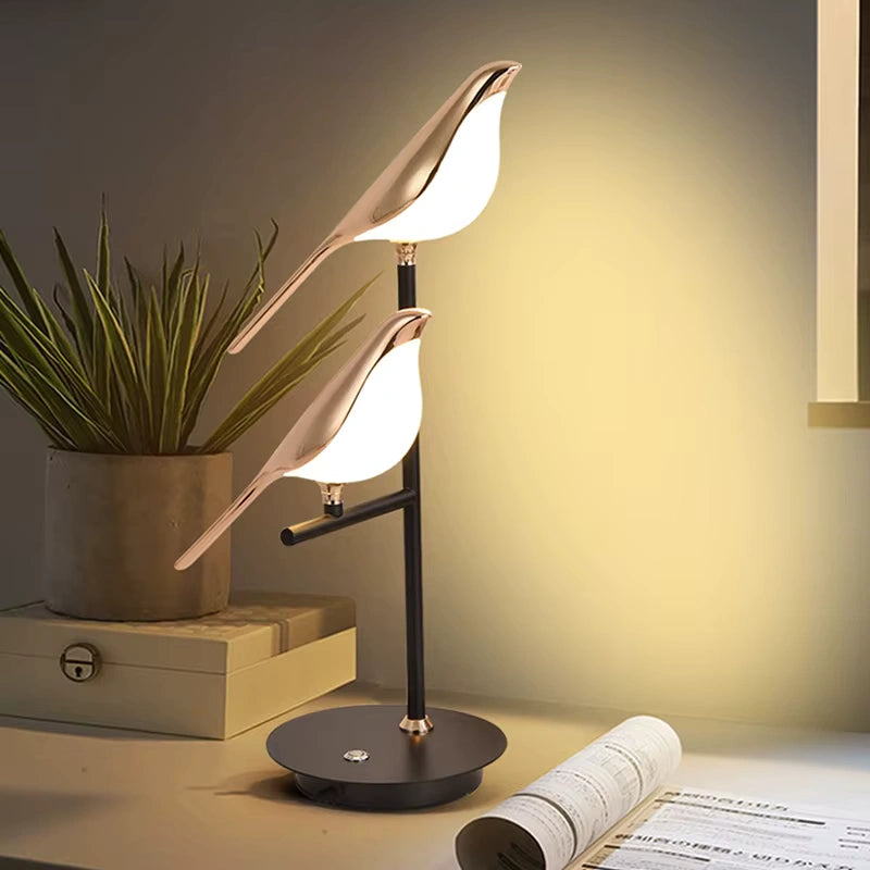 Elegant Bellvian bird LED lamp on dark bedside table, luxury bedroom lighting setup with warm golden glow.