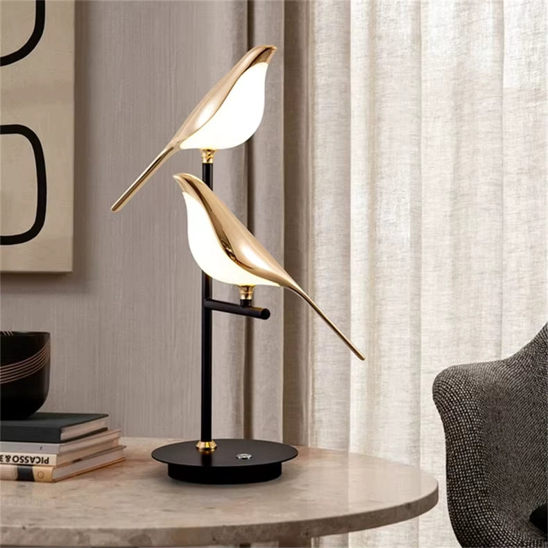 Bellvian gold bird LED table lamp with dual head design on marble table, modern minimalist home decor lighting for bedroom and living room.