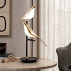 Bellvian gold bird LED table lamp with dual head design on marble table, modern minimalist home decor lighting for bedroom and living room.
