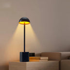 Elegant black LED table lamp emitting golden ambient light, perfect for living rooms, restaurants, and study areas. Bellvian modern cordless lamp for UK interiors.