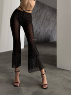 Close up detail of Bellvian black rhinestone mesh flared trousers featuring sparkling crystal embellishments sheer luxury fabric glamorous women's partywear UK premium evening outfit holiday fashion statement clothing birthday celebration wear luxury festival outfit designer inspired black fashion trousers and elegant occasion wear