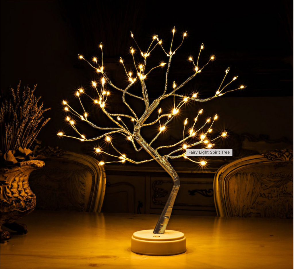 Golden LED Fairy Light Spirit Tree Lamp glowing warmly in a dark vintage room, placed on a wooden table with rustic decorative vases — cozy ambient lighting for home decor. Bellvian