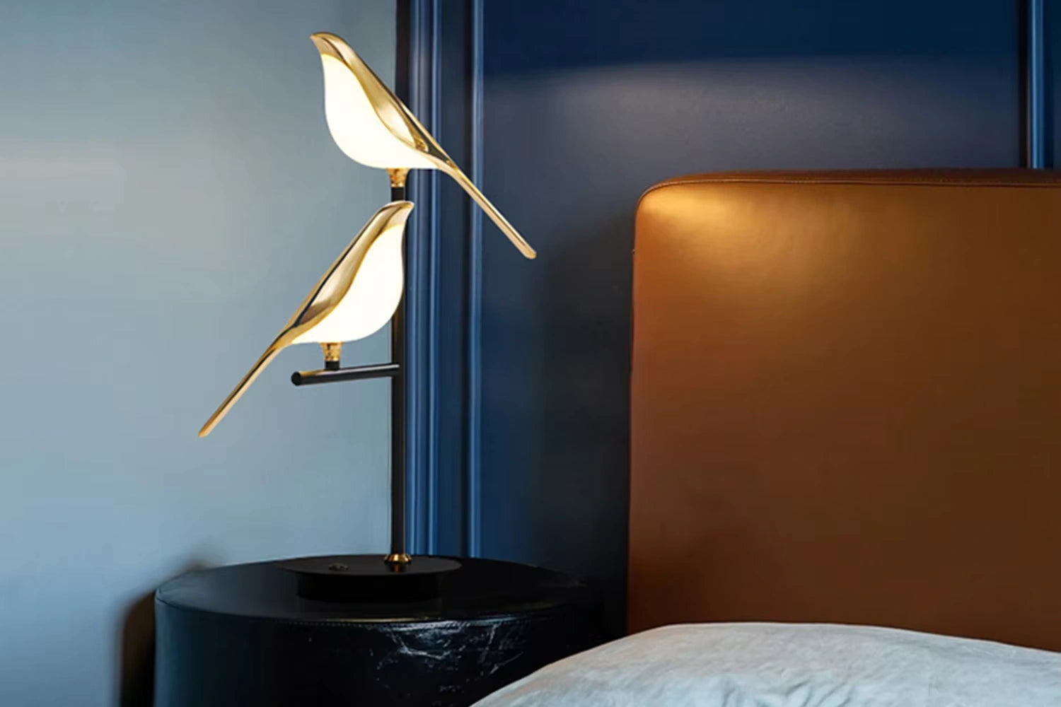 Bellvian gold bird LED lamp on bedside table, elegant modern lighting decor for bedroom interior.