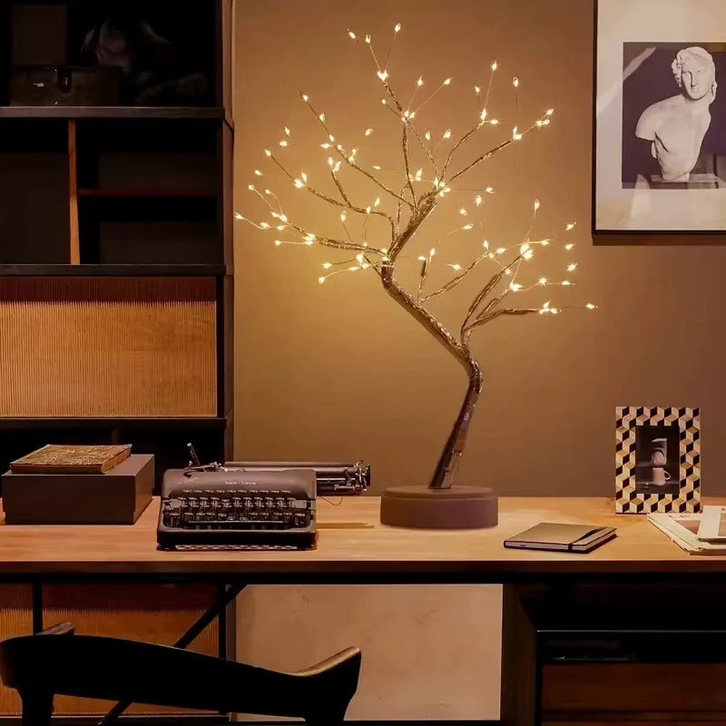 Large LED Bonsai Tree Lamp placed on a wooden desk with a vintage typewriter, notebooks, and art frame modern minimalist lighting for office or study space. Bellvian