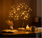 108 LED Fairy Light Tree Lamp illuminating a cozy wooden bedside table with an open book, candle, and coffee mug  perfect ambient night light for reading and relaxation. Bellvian