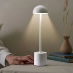 Modern white LED table lamp with touch control, minimalist design and soft warm glow on a bedside table – perfect for bedrooms, hotels, or home offices. Bellvian UK contemporary lighting.