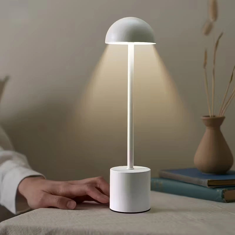 Modern white LED table lamp with touch control, minimalist design and soft warm glow on a bedside table – perfect for bedrooms, hotels, or home offices. Bellvian UK contemporary lighting.