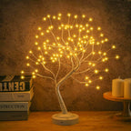 White Birch-style LED Fairy Tree Lamp with golden fairy lights glowing softly against a textured wall, surrounded by candles and books  elegant boho home decor lighting. Bellvian