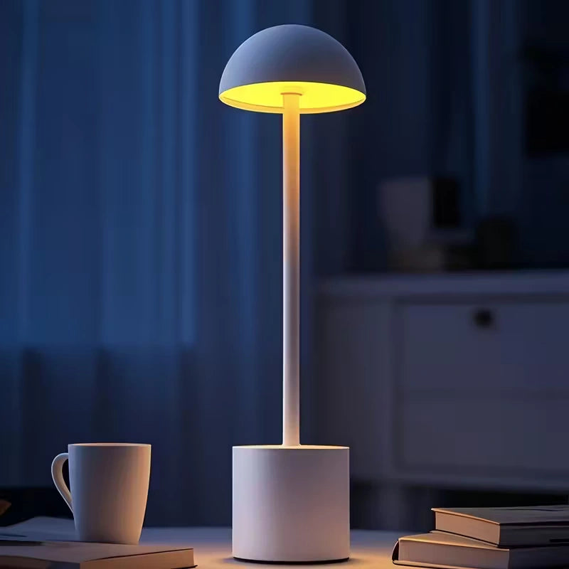 White rechargeable LED night lamp glowing softly on a table in a dark room, perfect for evening reading and cosy home lighting. Bellvian cordless lamp.