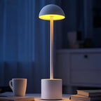 White rechargeable LED night lamp glowing softly on a table in a dark room, perfect for evening reading and cosy home lighting. Bellvian cordless lamp.