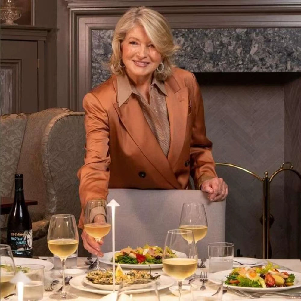 Elegant cordless LED table lamp on a fine dining table with wine glasses, white plates, and a woman enjoying dinner in a luxury restaurant.