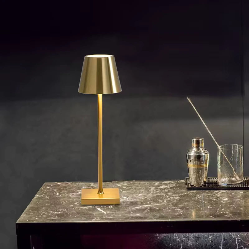 Luxurious gold LED table lamp placed on a marble table, creating a sophisticated ambient glow. Perfect for bars, lounges, and modern home décor styling.