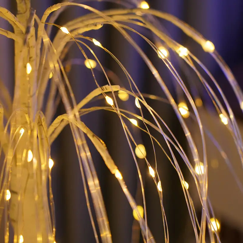 Close-up view of LED willow tree lamp showing flexible transparent branches with glowing warm yellow fairy lights. The intricate wire details highlight the lamp’s elegant craftsmanship and ambient lighting design for modern interiors.